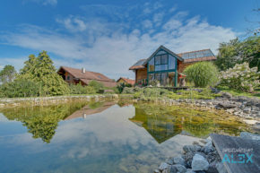 Fotografie von Verkaufs- & Vermietungs-Immobilien Blick über den Schwimmteich zum Holzhaus